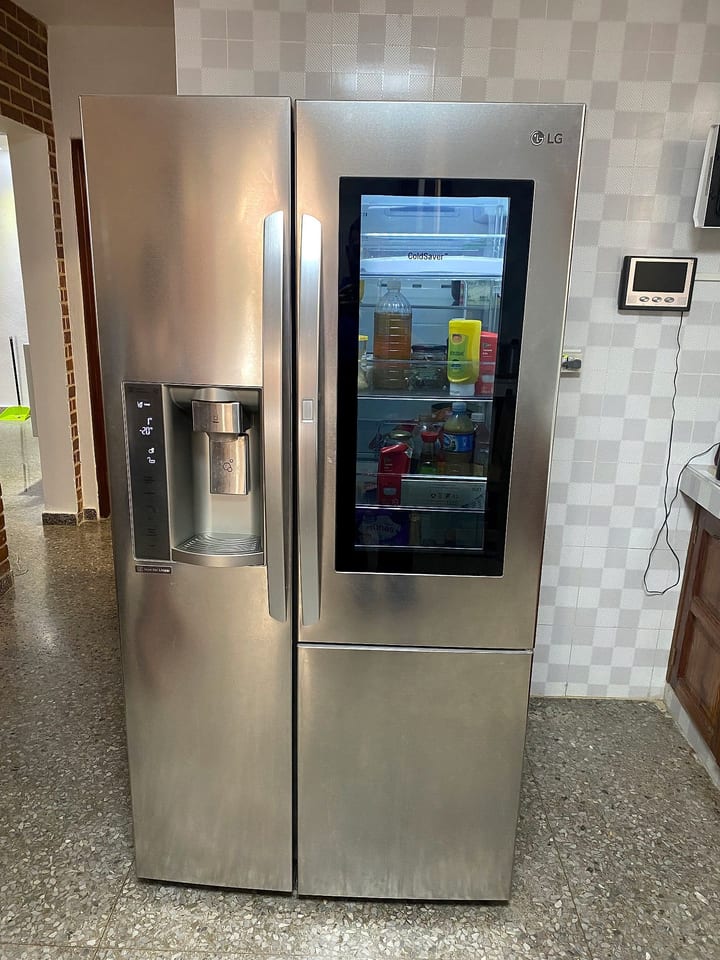 LG InstaView side-by-side refrigerator with the door-in-door window lit